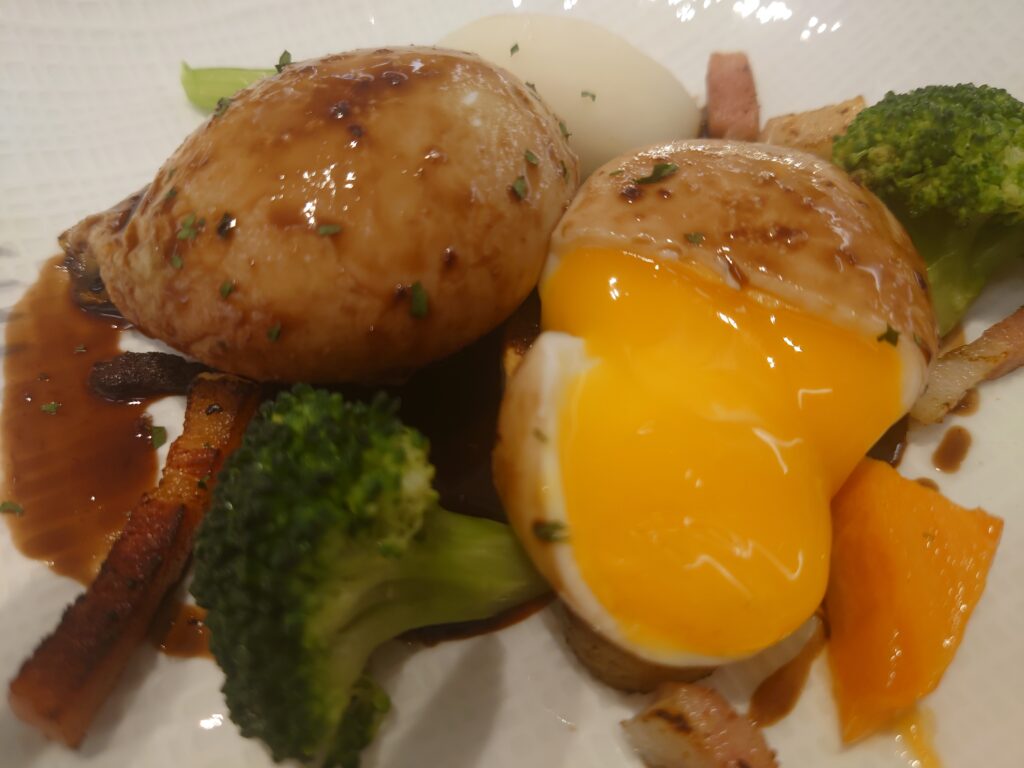 ポルトムインターナショナル北海道　朝食メニューの「ウフ・アン・ムーレット」の卵を割ると、中から黄身が出てきた