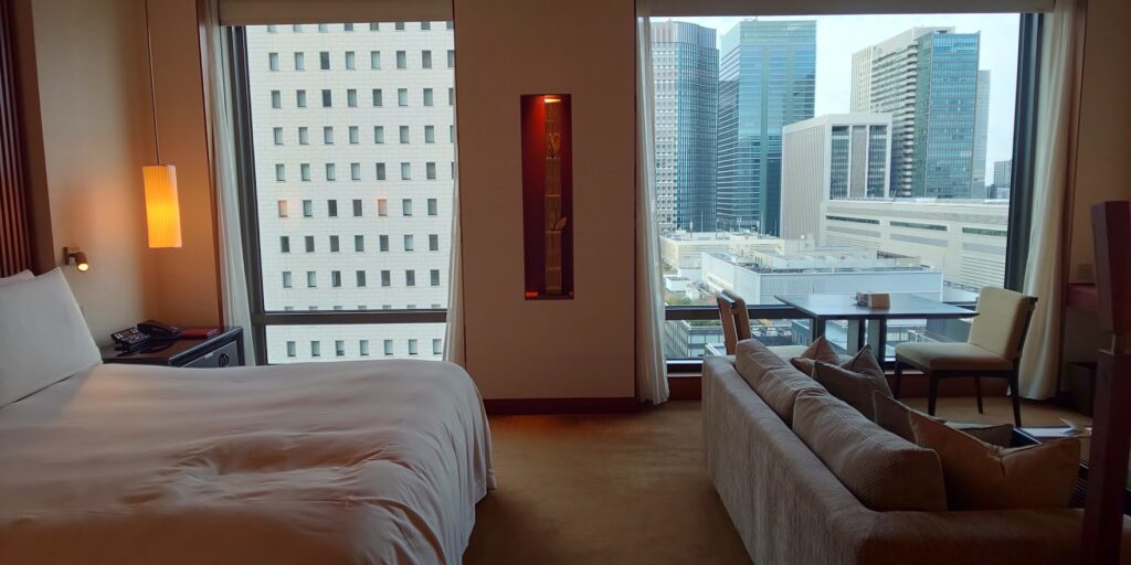 ザ・ペニンシュラ東京の部屋　ベッドとソファの向こうに大きな窓