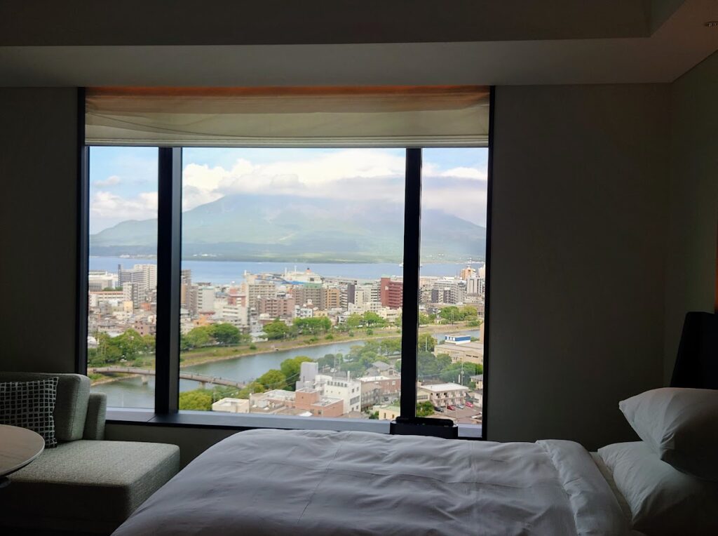 シェラトン鹿児島の部屋の窓から見える景色とソファとベッド