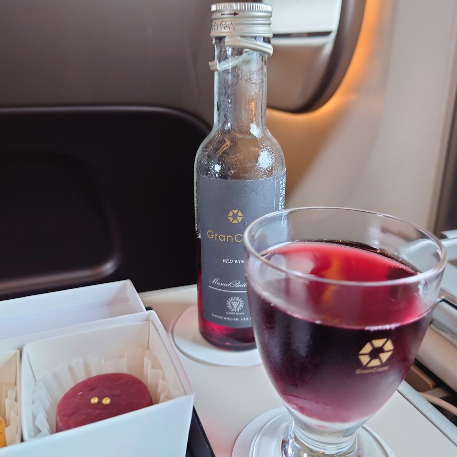 東京から新青森間の新幹線「はやぶさ」のグランクラスで注文した赤ワインを注いだグラス