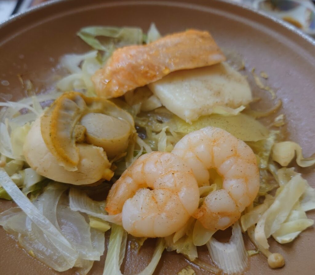 夕食のメニュー　海老、いか、さけなどの海産物の陶板焼きが出来上がっている　