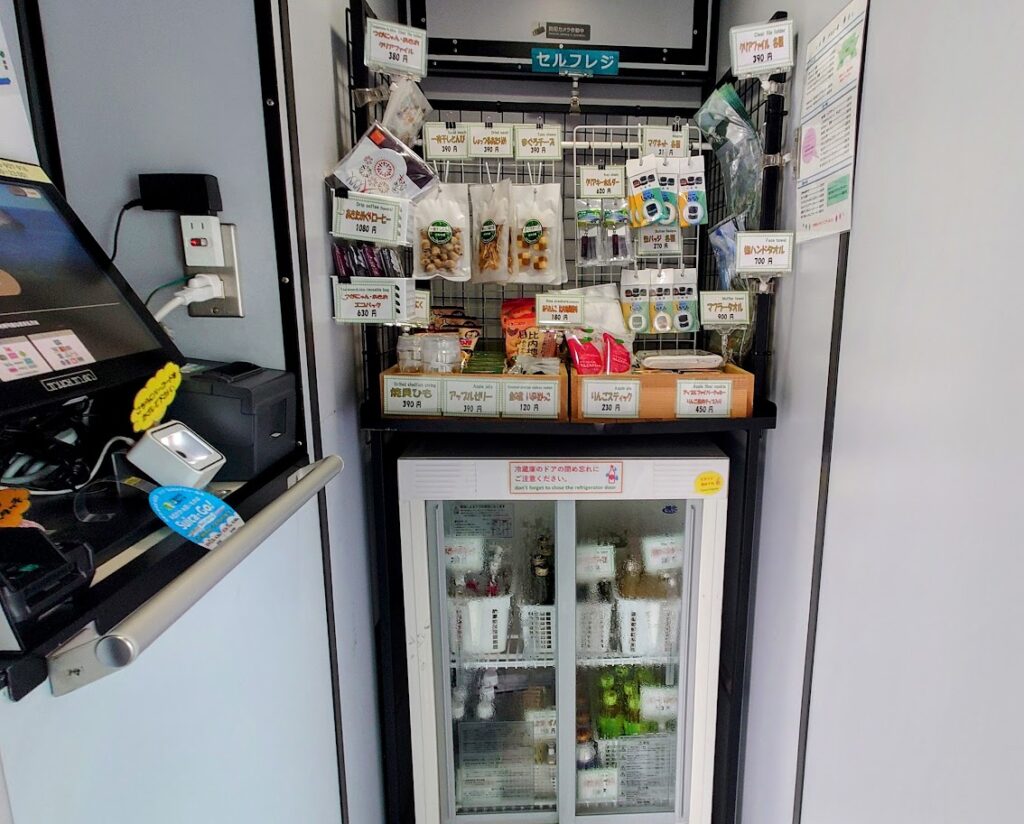 リゾートしらかみ号の車内にあるセルフレジ　飲み物の入った冷蔵庫、土産物などが並んでいる