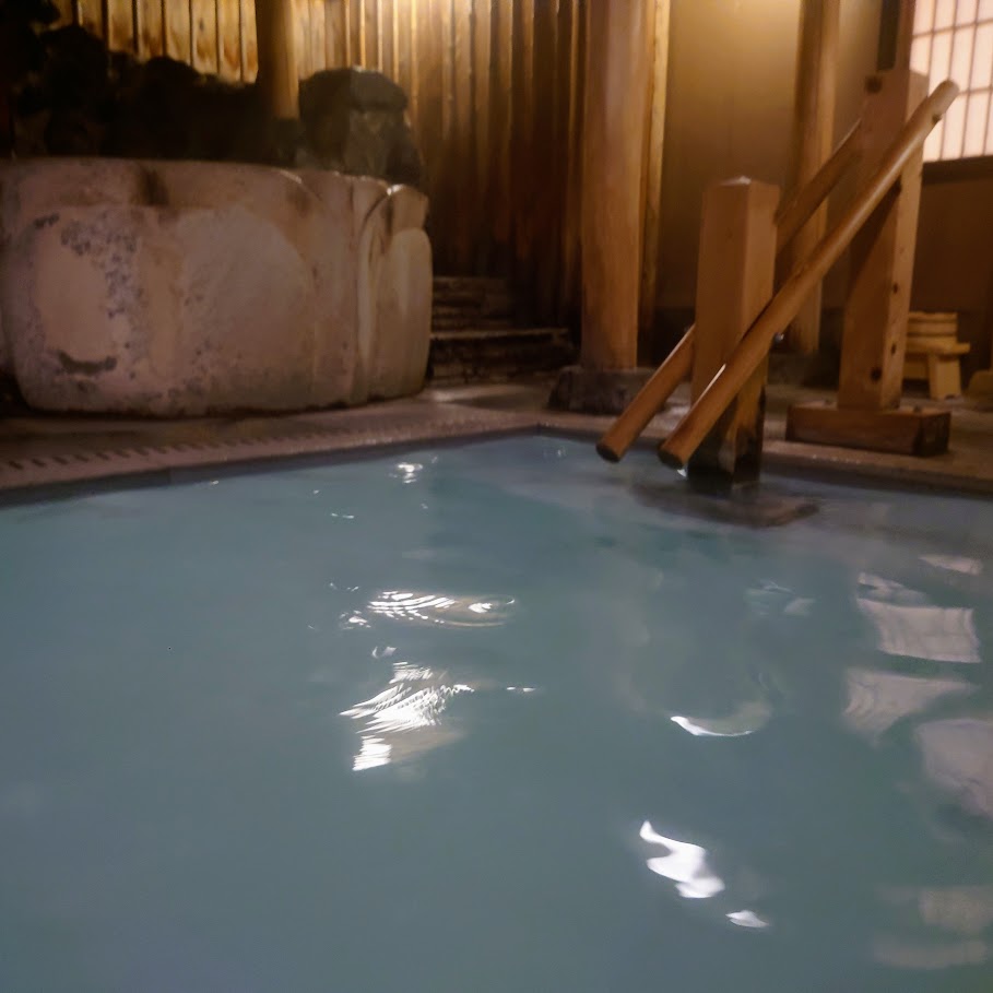 奈良屋の大浴場「花の湯」の露天風呂は、白濁した源泉がこんこんと湧き出ている。