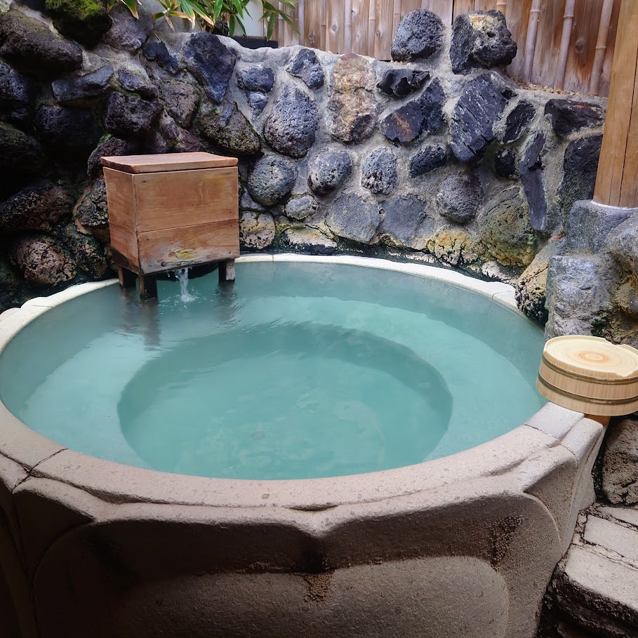 奈良屋の大浴場「花の湯」の露天風呂の小さめの浴槽は、石造りで丸い形をしている。