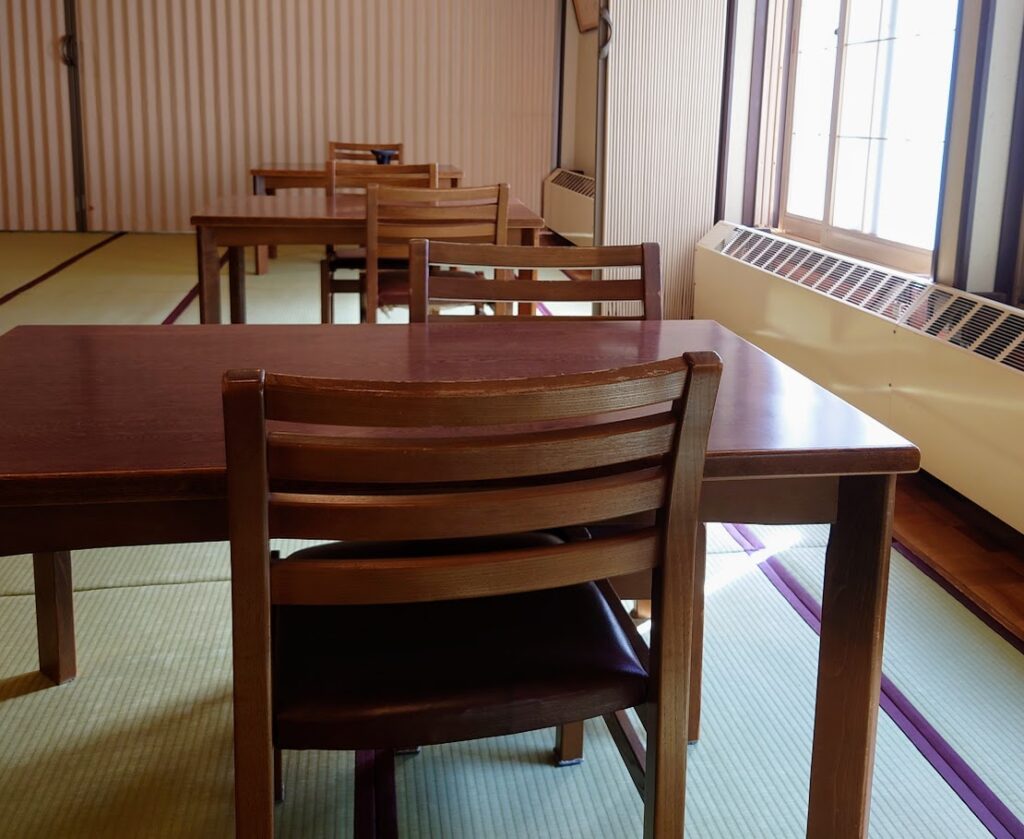 峡雲荘の朝食の会場　大広間に、テーブル、椅子が並んでいる