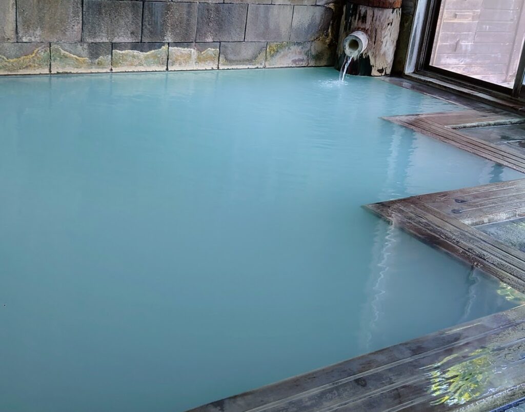 峡雲荘の大浴場　内風呂には、エメラルドがかった乳白色の温泉が湧き出ている
