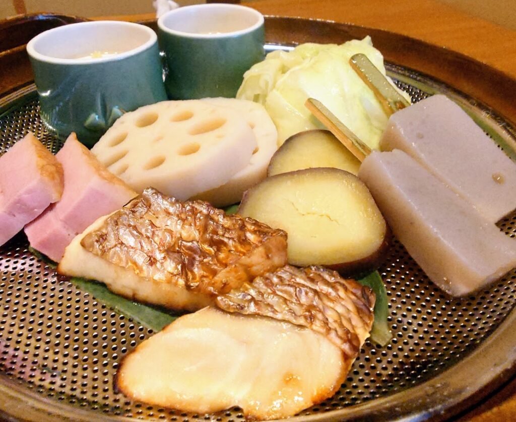 奈良屋の朝食の温かい食事。大きな土鍋の蓋を取ると、茶碗蒸しや温野菜、魚などがたっぷり入っていた。