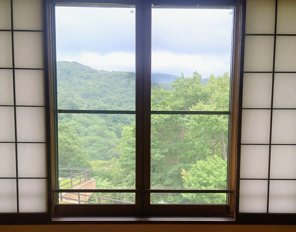 峡雲荘の本館和室　窓から美しい緑が見える