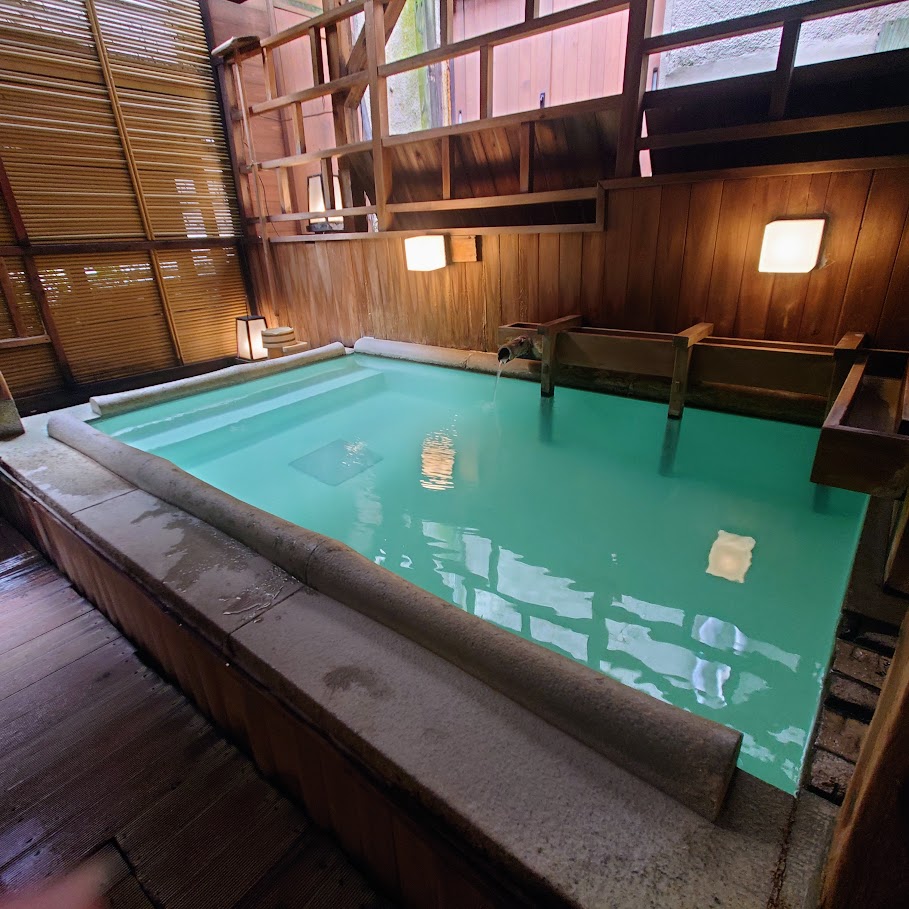 奈良屋の大浴場「御汲上の湯」の露天風呂から景色は見えないが、木の壁や柱で囲まれていて、情緒がある。