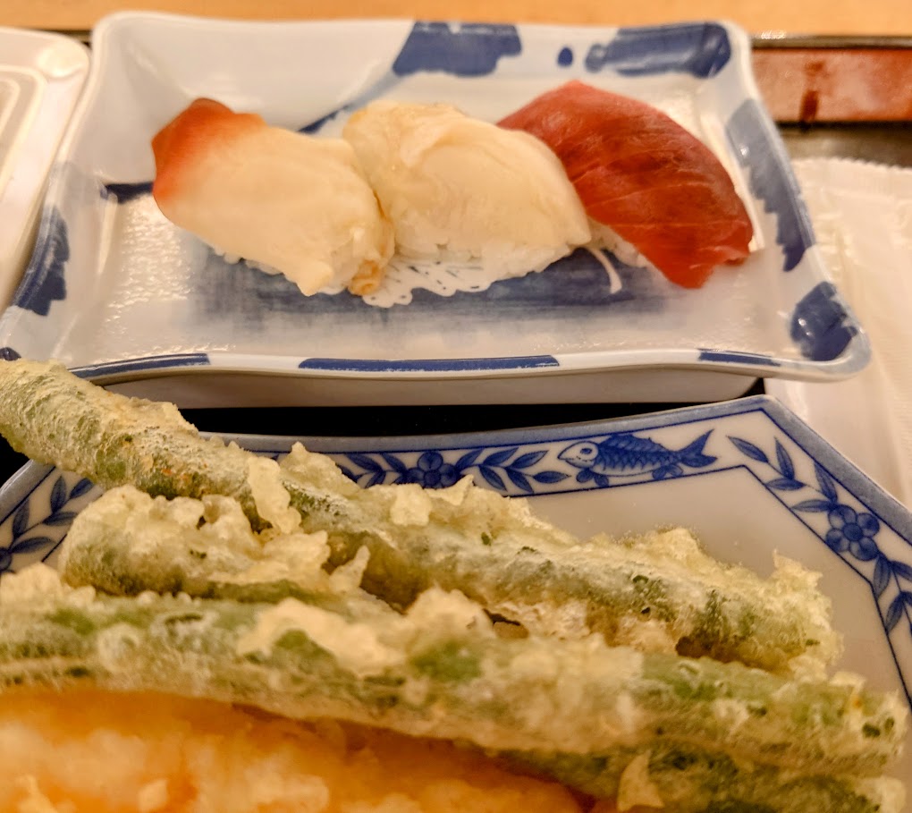 水上温泉「松乃井」の夕食ビュッフェ　　握り寿司、野菜やエビの天ぷらなどが皿にのっている