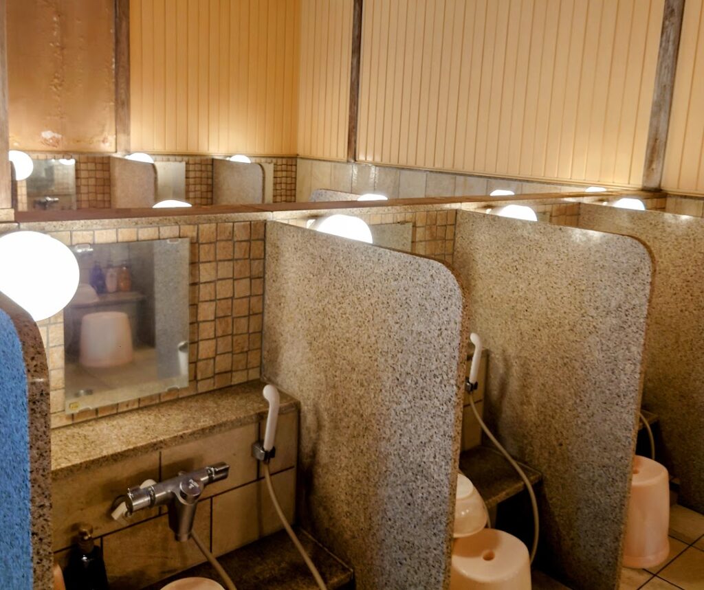 水上温泉「松乃井」の庭園風呂「蛍あかりの湯」の洗い場は、シャワーが仕切りで分かれていて使いやすい