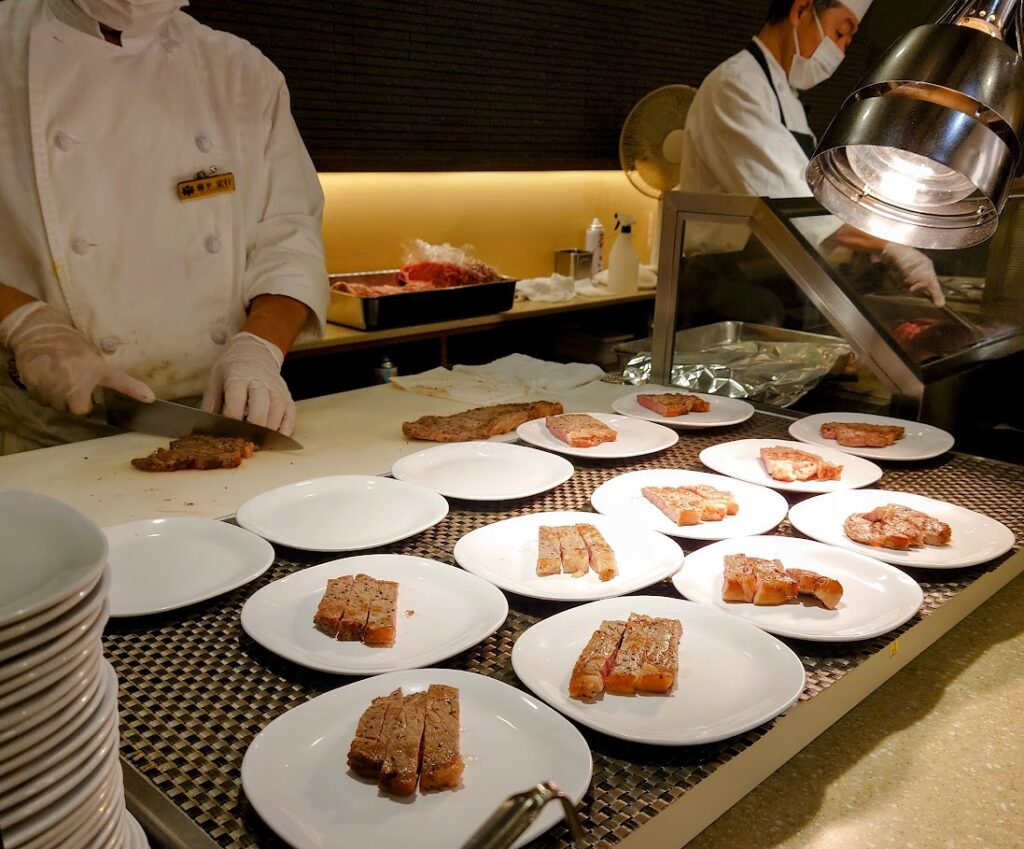 水上温泉「松乃井」の夕食ビュッフェのライブキッチンでは、ステーキを焼いて提供している
