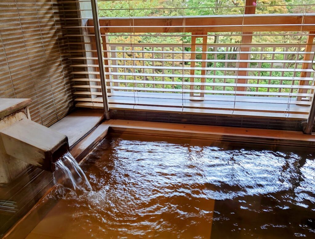 水上温泉「松乃井」露天風呂付客室　露天風呂では、源泉が湯船の中に勢いよく流れこんでいる