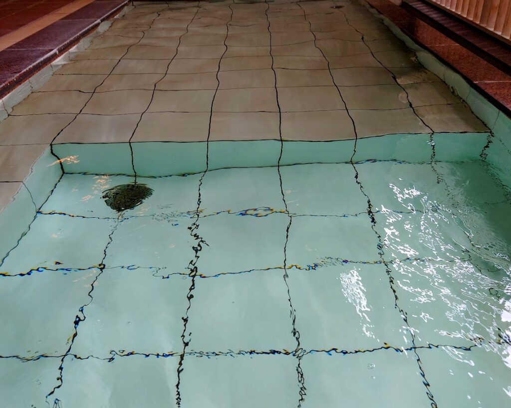 水上温泉「松乃井」の大浴場「月あかりの湯」　露天風呂の床は、一部高くなっている