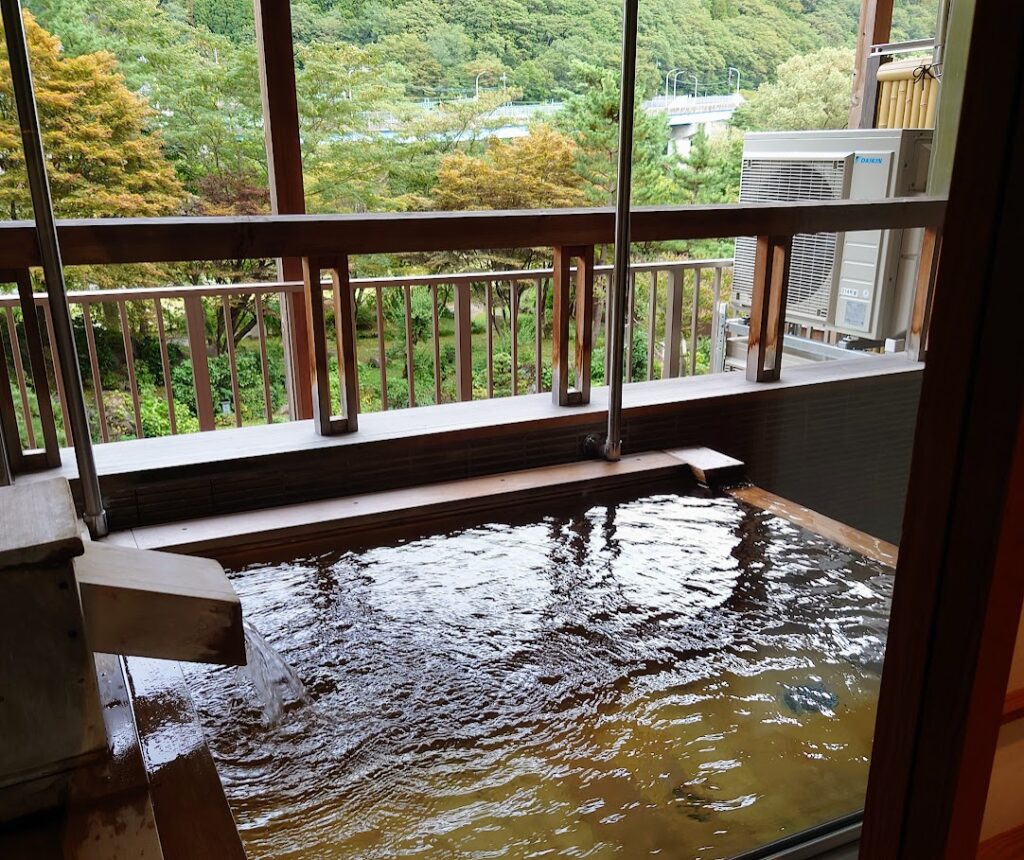 水上温泉「松乃井」露天風呂付客室の部屋の窓を大きく開けて、露天風呂を見たところ