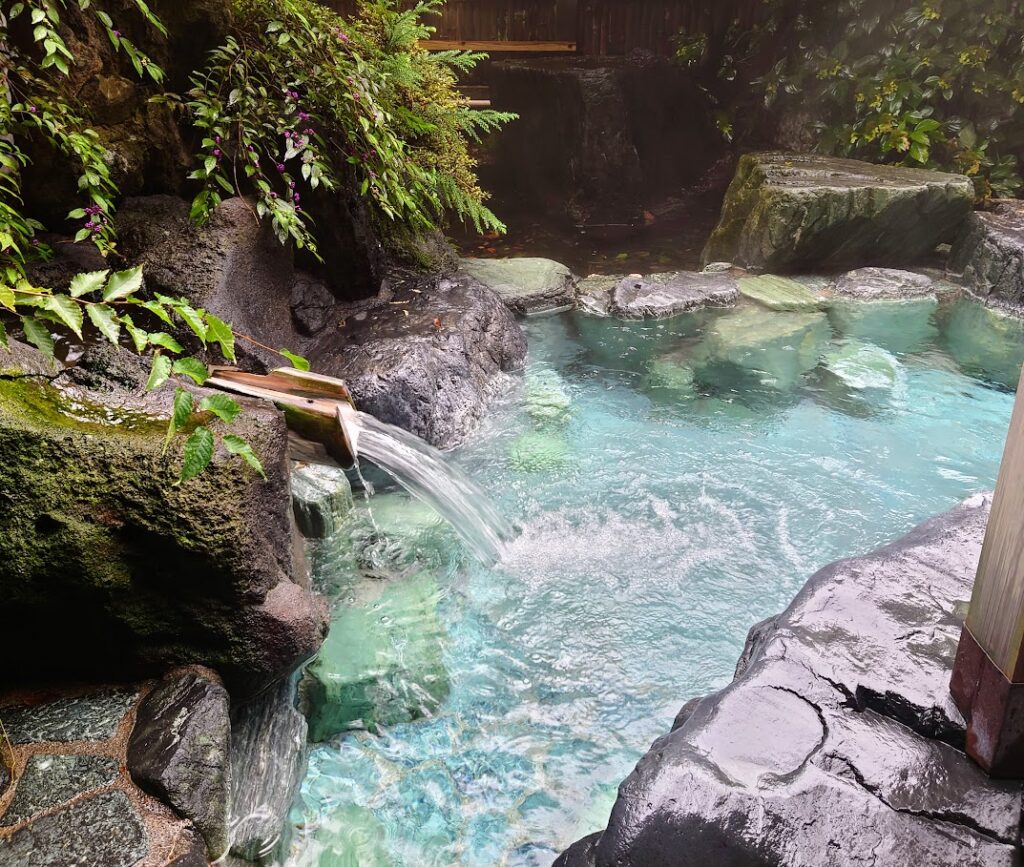 水上温泉「松乃井」の大露天風呂「火あかりの湯」　屋根のない露天風呂は、自然に囲まれて野性味あふれる雰囲気