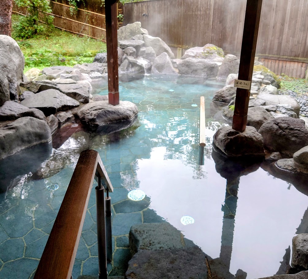 水上温泉「松乃井」の庭園風呂「蛍あかりの湯」の露天風呂は、右に進むと深くなっている